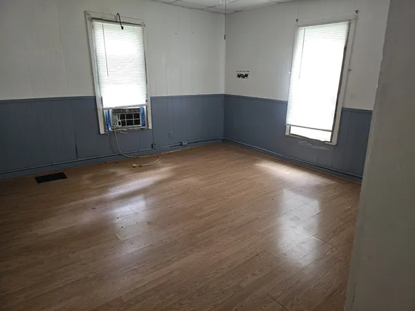 a room with wooden floor and a window