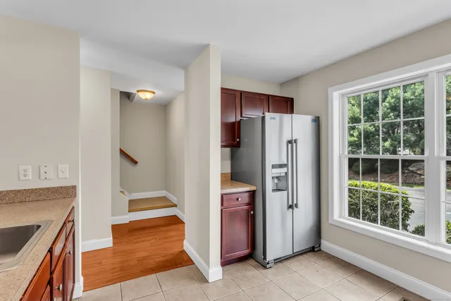 a view of a kitchen with refrigerator and wooden floor