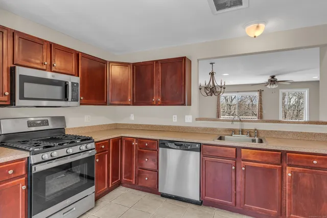 a kitchen with granite countertop cabinets stainless steel appliances and a sink