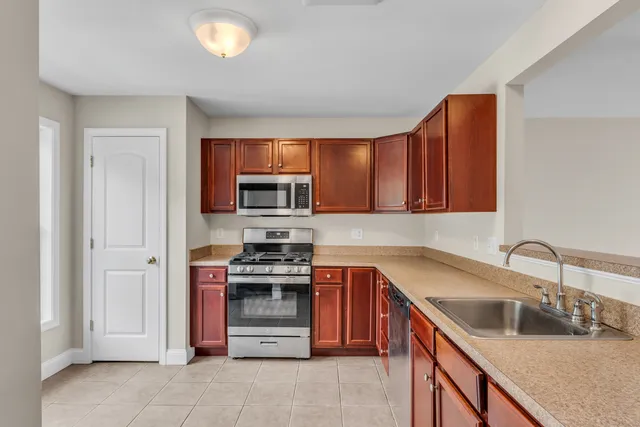 a kitchen with stainless steel appliances granite countertop a sink stove and refrigerator