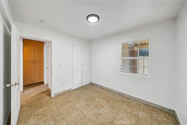 an empty room with windows and closet