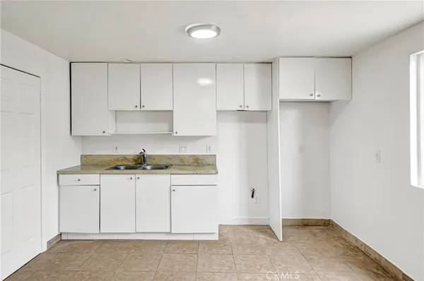 a kitchen with granite countertop white cabinets and stainless steel appliances