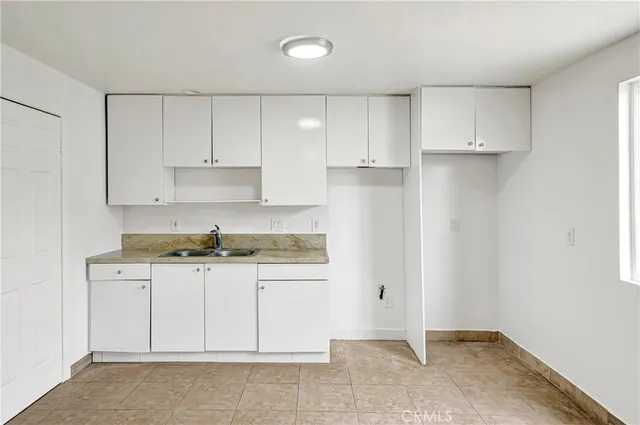 a kitchen with granite countertop white cabinets and stainless steel appliances