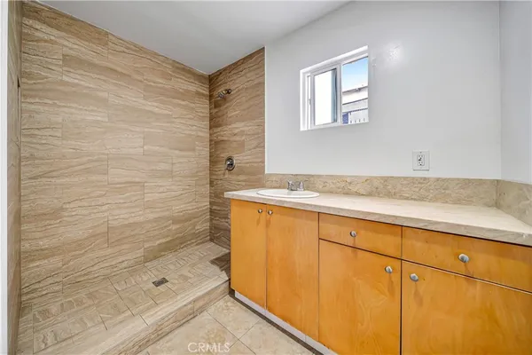a bathroom with a granite countertop sink and a bathtub