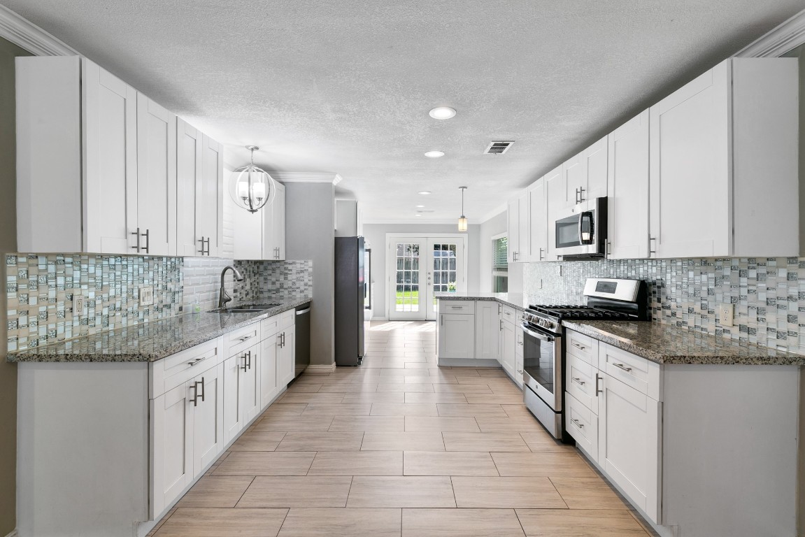 Bright kitchen featuring timeless white shaker cabinets and granite countertops.