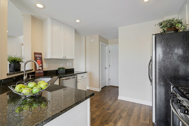 15324 Pinewood Road Lockport, IL 60441 - Photo 6 of 18 a kitchen with stainless steel appliances kitchen island granite countertop a refrigerator a stove a sink a dining table and chairs with wooden floor