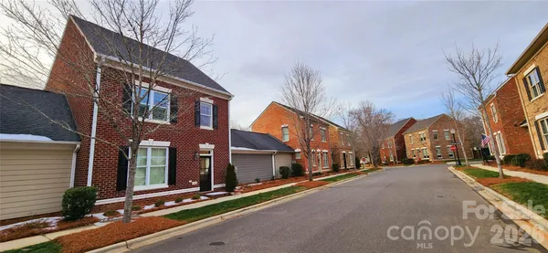 a kitchen with stainless steel appliances granite countertop a refrigerator a sink dishwasher a stove and white cabinets with wooden floor
