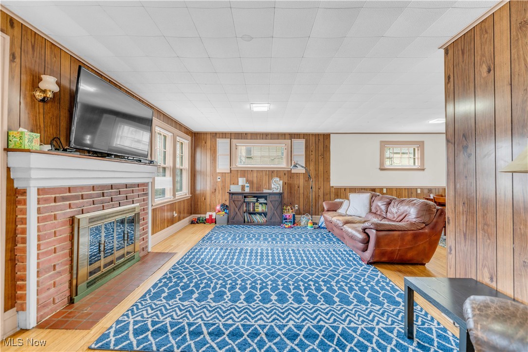 3729 Grosvenor Road Cleveland, OH 44118 - Photo 13 of 39 Living room featuring wooden walls, a healthy amount of sunlight, and light wood-style flooring