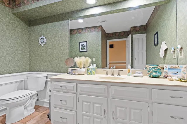 a bathroom with a toilet a sink and mirror