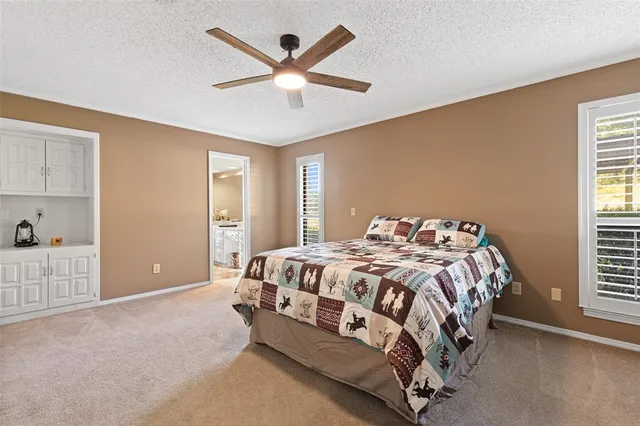 a bed sitting in a bedroom next to a window and a chandelier