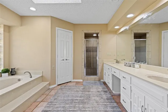 a spacious bathroom with a double vanity sink a mirror and a bathtub