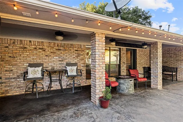 a view of a chairs and table in the back yard of the building