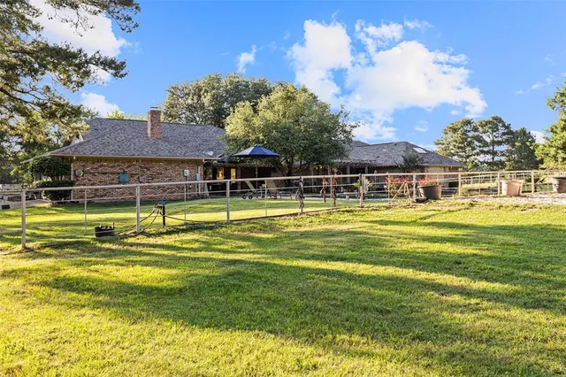 a view of a swimming pool with a lawn chairs under an umbrella