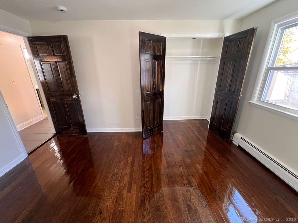 193 City View Avenue Bridgeport, CT 06606 - Photo 11 of 16 an empty room with wooden floor and a window