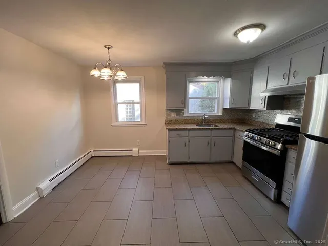 a kitchen with granite countertop a sink cabinets and stainless steel appliances