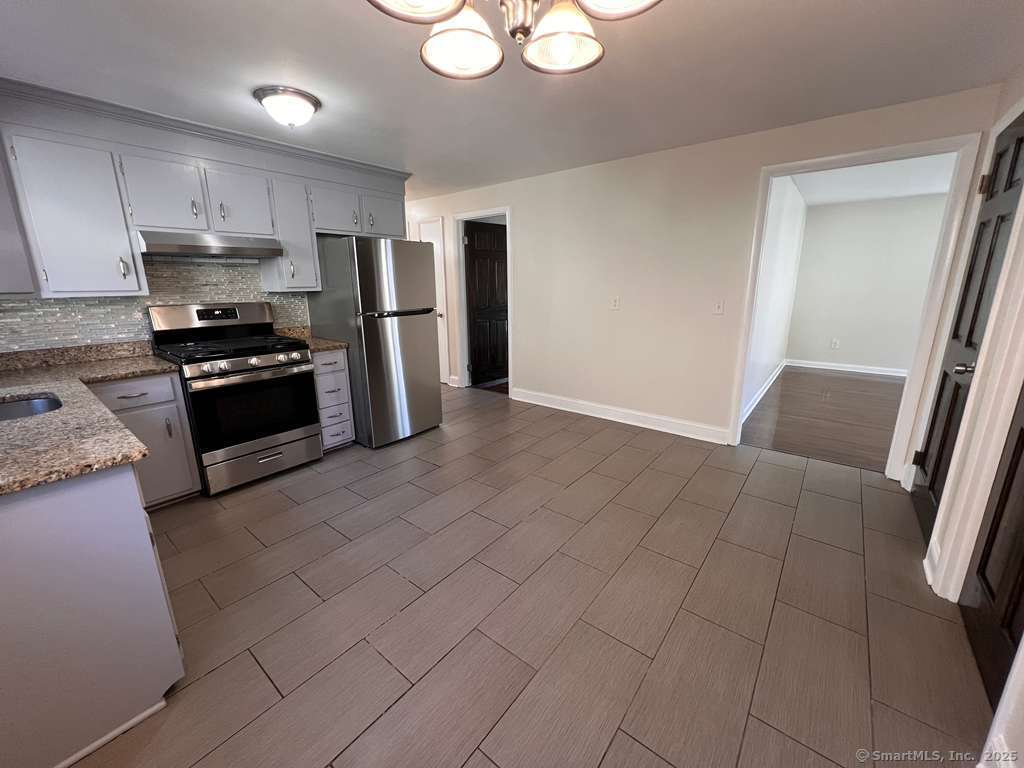 193 City View Avenue Bridgeport, CT 06606 - Photo 13 of 16 a kitchen with stainless steel appliances granite countertop a refrigerator and a stove top oven