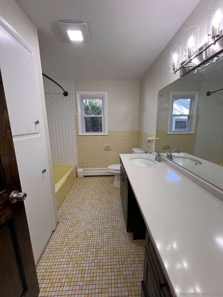 193 City View Avenue Bridgeport, CT 06606 - Photo 7 of 16 a bathroom with a sink a toilet a mirror and window