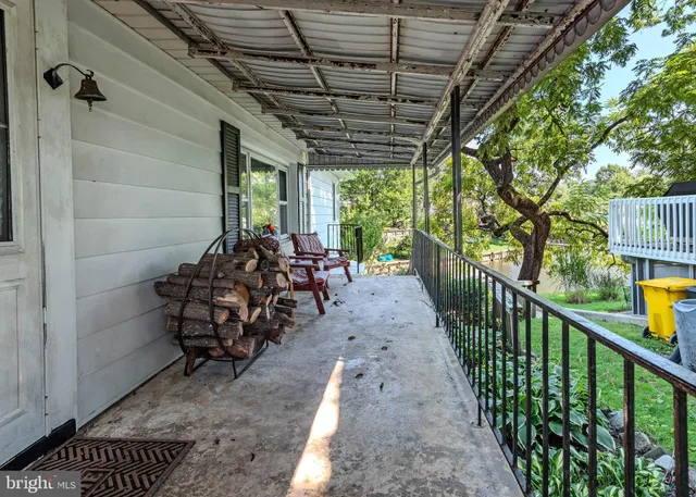 a view of an empty room with window and chandelier fan
