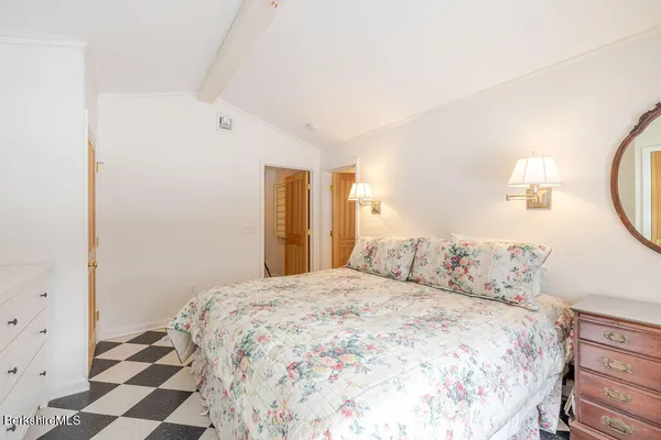 a bedroom with a bed and a mirror on dresser