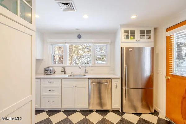 a kitchen with stainless steel appliances a refrigerator sink and cabinets