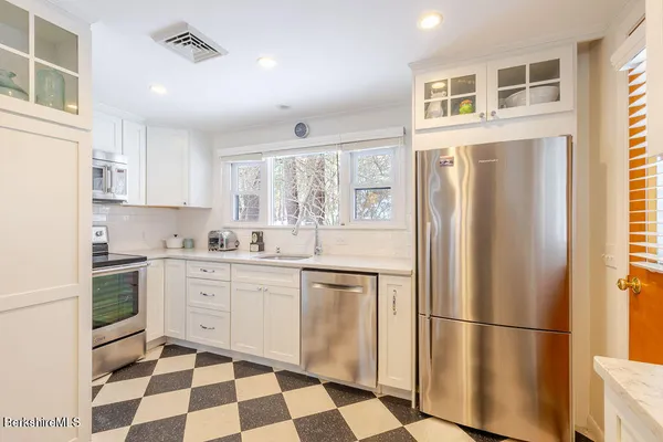 a kitchen with stainless steel appliances a refrigerator sink and microwave