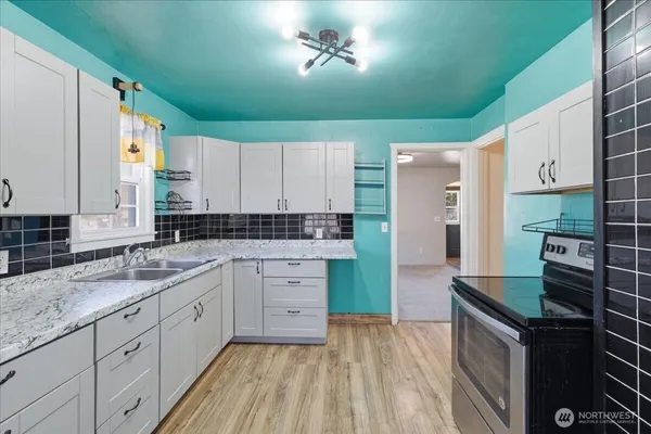 a kitchen with granite countertop a sink stainless steel appliances and cabinets