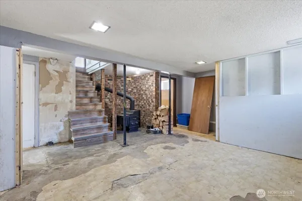 a view of an empty room with wooden floor and stairs