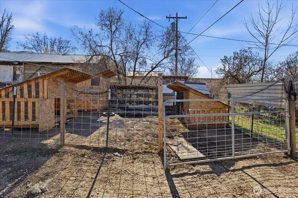 a view of a yard with wooden fence and a bench