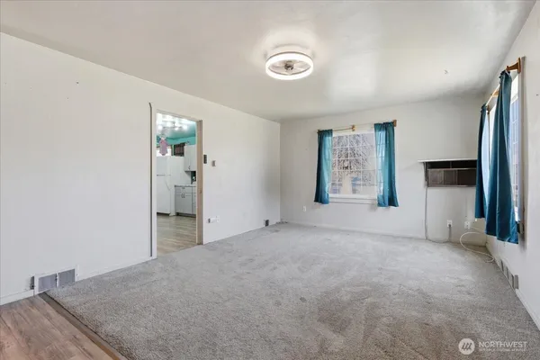 a view of a livingroom with wooden floor and a ceiling fan