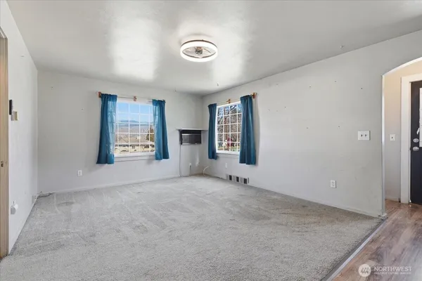 an empty room with windows and closet