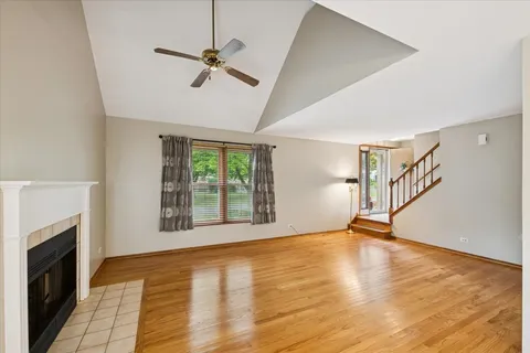 a view of an empty room with a fireplace and wooden floor