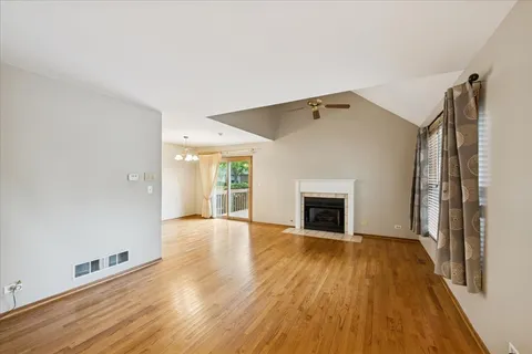 a view of a livingroom with wooden floor and a fireplace