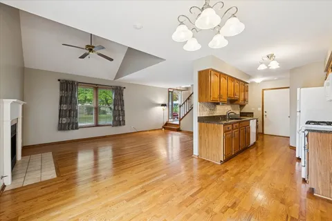 a kitchen with stainless steel appliances a stove top oven a refrigerator cabinets and wooden floor