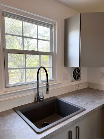 a kitchen with a sink a counter and a window