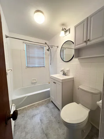 a bathroom with a granite countertop toilet sink and mirror