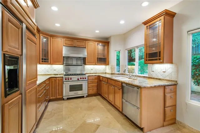 a kitchen with granite countertop a sink stove and refrigerator