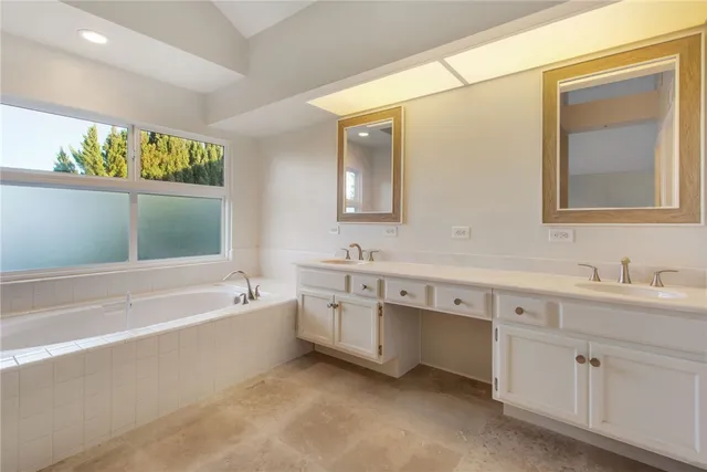 a bathroom with a tub sink and mirror