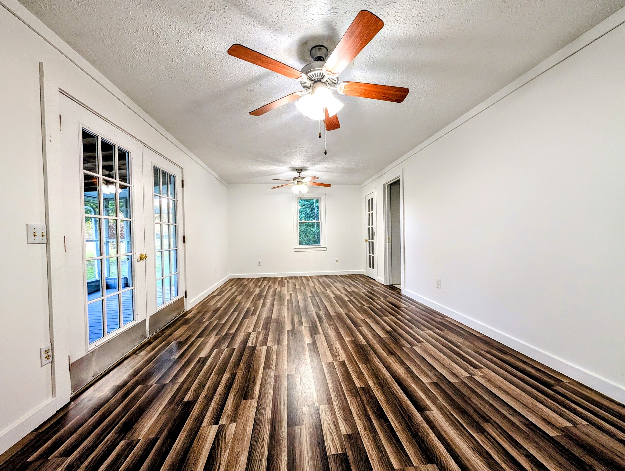 637 Robinson Road Centerville, TN 37033 - Photo 14 of 19 a view of an empty room with wooden floor and a ceiling fan