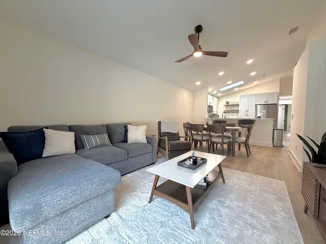 a living room with furniture and kitchen view