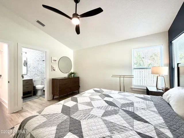 a bedroom with a bed large mirror and furniture