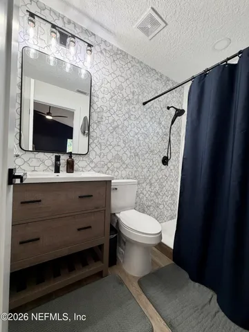 a bathroom with a toilet a sink and a mirror