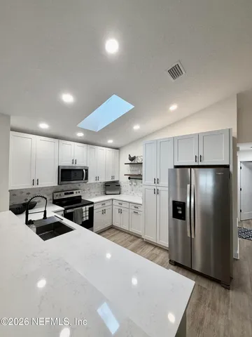 a kitchen with refrigerator a microwave and cabinets