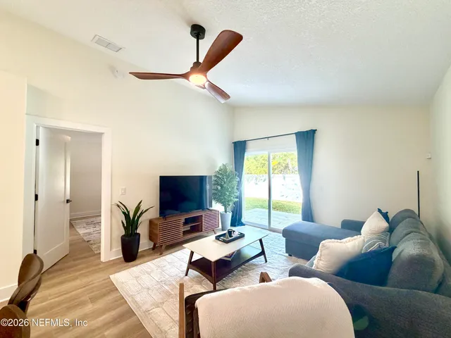 a living room with furniture ceiling fan and a window