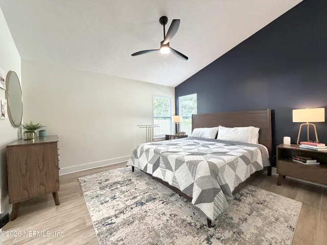 a bedroom with a bed and a dresser with wooden floor