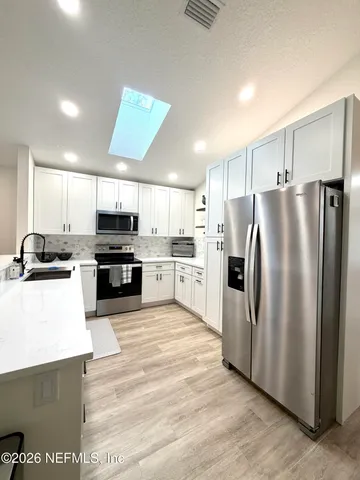 a kitchen with stainless steel appliances granite countertop a refrigerator sink and stove