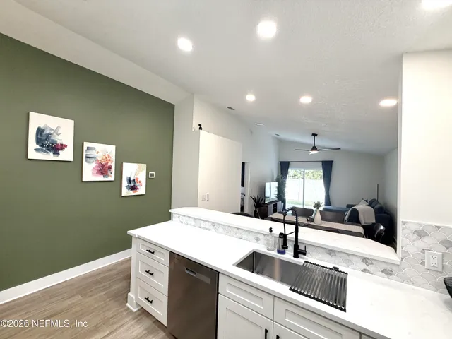 a view of a kitchen with a sink and a refrigerator
