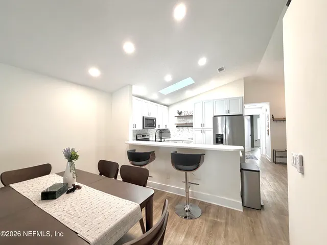 a living room with furniture and view of kitchen