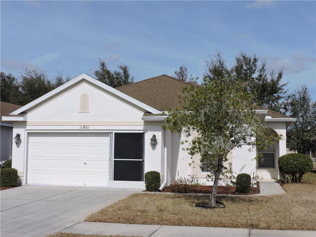 11861 Valley Falls Loop Spring Hill, FL 34609 - Photo 1 of 1 a view of a white house with a yard and plants