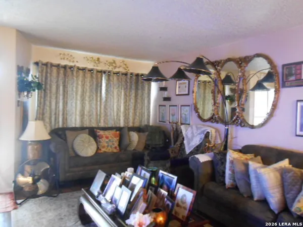 a living room with furniture a mirror and a window