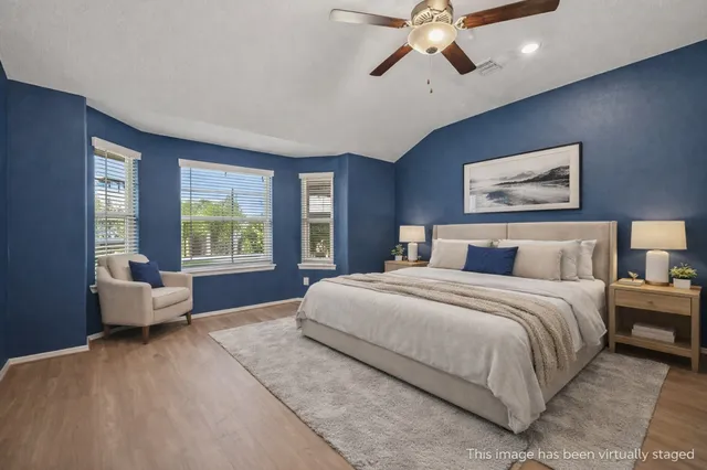 a spacious bedroom with a large bed and a chandelier